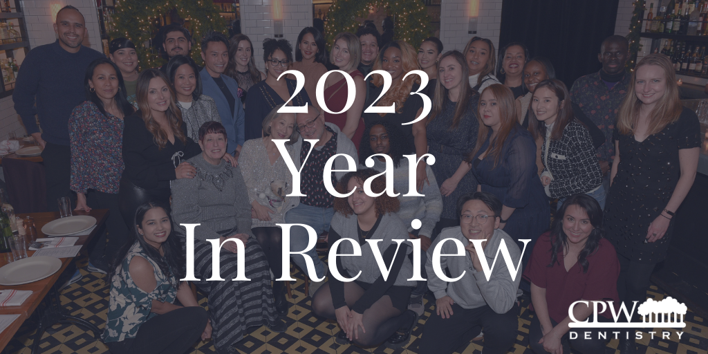 Group photo of the CPW Dentistry team at a festive event, overlaid with the text “2023 Year In Review,” showing smiling staff in a warmly lit restaurant.