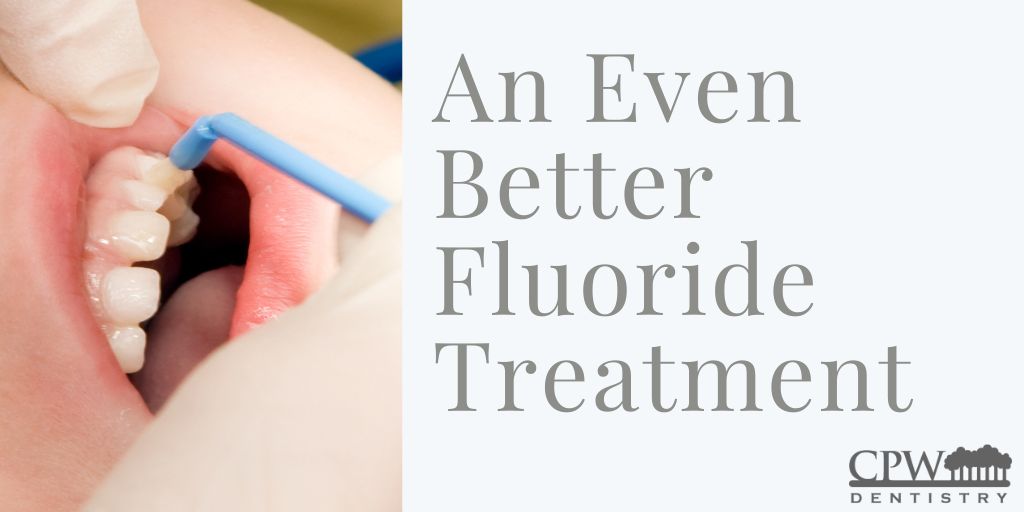 A child receiving fluoride from a gloved provider with “An Even Better Fluoride Treatment” overlaid in text.